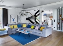 W części dziennej, zajmującej niemal cały parter, toczy się życie rodzinne i towarzyskie. Schody ze szklaną balustradą (Stol-Art) dzielą ją na dwie strefy: kuchenną oraz wypoczynkową. W części wypoczynkowej króluje szara narożna kanapa (Primavera Furniture), którą ożywiają poduszki z pakamera.pl. W części dziennej, zajmującej niemal cały parter, toczy się życie rodzinne i towarzyskie. Schody ze szklaną balustradą (Stol-Art) dzielą ją na dwie strefy: kuchenną oraz wypoczynkową. W części wypoczynkowej króluje szara narożna kanapa (Primavera Furniture), którą ożywiają poduszki z pakamera.pl.