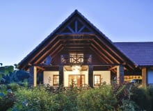 Silnie wysunięty dach, wsparty na kamiennych słupach, w niepogodę osłania balkon i taras przed opadami, a w upalne dni chroni korzystających z nich domowników przed intensywnym słońcem dom w nocy, elewacja ogrodowa, dach