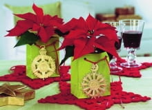 Ze złotym medalionem<br> Doniczki z poinsecją wstawiamy do papierowych torebek na prezenty. Do sznureczków przyczepiamy choinkowe zawieszki.