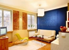 Warszawski Barbakan, na który wychodzą okna mieszkania, zainspirował projektantkę do odsłonięcia cegieł na fragmentach ścian w pokoju dziennym. Reliefy między cegłami i nad kanapą to również jej pomysł i wykonanie. UWAGA PONOWNA PUBLIKACJA ZA ZGODA WLASCICIELI