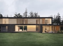 Willa zaprojektowana na leśnej działce. Użyte w projekcie materiały: jasne drewno, ciemny kamień, ekran z żywych roślin oraz duże przeszklenia sprawiają, że dom idealnie wpisuje się w leśny krajobraz. Projekt willi usytuowanej na leśnej działce.