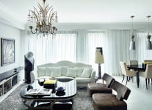 Dzięki użyciu kilkunastu odcieni bieli, kremów i czerni wnętrze nie jest oczywiste. Z drugiej strony, paleta ponadczasowych, eleganckich barw pozwoliła projektantowi utrzymać dyscyplinę. Sofa, stolik kawowy, fotele i lampy - IPE Cavalli. Żyrandol zdobiony kryształami przywieziony z antykwariatu w Monte Carlo.