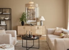 Wokół komody warto stworzyć dekoracyjną przestrzeń. Na ścianie można powiesić obraz lub plakat a na blacie ustawić lampę, wazon i bibeloty.