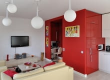 W centralnej części mieszkania architekci postawili czerwony kubik. Od strony kuchni mieszczą się w nim szafki kuchenne i lodówka, a od strony korytarza - szafy, pralka oraz małe biuro. nowoczesne mieszkanie, jak urządzić mieszkanie, mieszkanie w stylu loft, miniloft