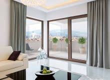 Barwa drewnianych ram okiennych harmonijnie wpisuje się w nowoczesną aranżację wnętrza