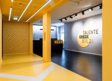 Już na wejściu do Talente Check Berlin przestrzeń nawiązuje do przejścia za kulisy sceny. Gwiazdy na ścianach i sceniczne oświetlenie mają zachęcać do szukania talentów. Już na wejściu do Talente Check Berlin przestrzeń nawiązuje do przejścia za kulisy sceny. Gwiazdy na ścianach i sceniczne oświetlenie mają zachęcać do szukania talentów.