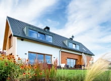 Wykorzystanie stonowanej kolorystyki i naturalnych materiałów, jak drewno czy kamień było jednym z głównych założeń projektowych. Oba te materiały pojawiają się zarówno na elewacjach, jak i wewnątrz domu dom nowoczesny