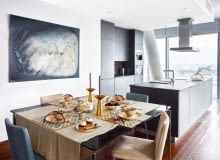 Obraz Doroty Buczkowskiej nad stołem w jadalni akcentuje szarości dominujące w tej części apartamentu. Na stole (Alivar): miseczki (Scandinavian Living), sztućce, obrus, i świeczniki (NAP). Wazon na kuchennej wyspie (Scandinavian Living). Meble w kuchni (Alno), sprzęt AGD (Miele).