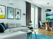 Rozłożystą, modułową sofę wykończoną zmywalną, wytrzymałą tkaniną zaprojektowała Joanna Kiryłowicz. Na podłodze w całym mieszkaniu olejowany dąb w naturalnym odcieniu. Z tego samego drewna wykonano większość mebli.