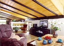 Sufit, obłożony sosnowymi deskami, podtrzymują belki z bejcowanego dębu.