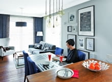 SPORY STÓŁ (ze sklepu Take me Home) z tapicerowanymi krzesłami (domartstyl.eu) przystawiono do wyspy. Ewa i Marek bardzo sobie chwalą to rozwiązanie, bo przygotowując posiłek dla gości, nie czują się wyłączeni z życia towarzyskiego. Ozdobą tej części pomieszczenia jest galeria grafik, zdjęć i plakatów oprawionych w białe i czarne ramki. Nad stołem - siedem lamp-żarówek (bylight.pl).