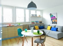 Po połączeniu kuchni z pokojem powstała spora strefa dzienna. Z jej nowoczesnym wystrojem harmonizują dekoracyjne dodatki nawiązujące do lat 60., kiedy wybudowano mieszkanie. Nadrukowane na blachach i na płótnie plakaty reklamujące osiągnięcia PRL-owskiej motoryzacji zostały kupione w sklepie Reset, który specjalizuje się w stylu vintage.