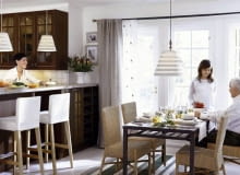 Szereg stojących szafek kuchennych w wyraźny sposób oddziela strefę kuchni od salonu