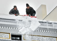 Prace związane z usuwaniem śniegu z dachu mogą wykonywać osoby posiadające aktualne badania lekarskie, zezwalające do pracy na wysokości lub wyspecjalizowane w tym zakresie. 14.01.2010 LODZ , UL PIOTRKOWSKA 104 , ODGARNIANIE SNIEGU Z DACHU URZEDU MIASTA , PRACOWNICY BEZ ZABEZPIECZEN USUWAJA SNIEG Z DACHU BUDYNKU . FOT. TOMASZ STANCZAK / AGENCJA GAZETA