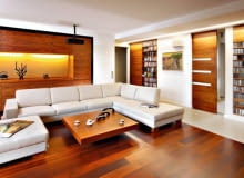 <b> ŁADNIE SCHOWANE. Szafki i regały w salonie powinny nie tylko dobrze spełniać swoją funkcję, ale i estetycznie wyglądać. A to zależy od formy mebli oraz materiału, z jakiego są zrobione. </b> <BR /> Właścicielom, kinomanom i melomanom z zamiłowania, zależało na przechowywaniu w salonie bogatych zbiorów filmów i płyt muzycznych. Potrzebowali więc pojemnych schowków, ale takich, które nie dominowałyby nad wypoczynkową funkcją pomieszczenia. Projektanci zaproponowali zbudowanie w ściennych wnękach otwartych półek na płyty CD i DVD, które prezentują się efektownie, oraz zamykanych szafek na rzeczy nie do eksponowania. Zabudowa okazała się trafionym pomysłem - nie przytłacza wnętrza tak jak masywne wolno stojące meble. Lekka forma schowków idzie w parze z urodą drewna orzechowego, z jakiego zostały zrobione. <BR /> Kredens w nowoczesnym wydaniu. Obszerną wnękę w jednej ze ścian zabudowano szafkami zamykanymi pełnymi drzwiczkami bez uchwytów. We wnęce w środku tej zabudowy gospodarze eksponują dekoracyjne drobiazgi.