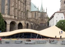 U stóp gotyckiej katedry w Erfurcie powstaje niezwykła scena plenerowa. Wystąpią na niej operowe sławy, które czeka spore wyzwanie. Oprócz umiejętności wokalnych będą musiały udowodnić tu bezbłędne wyczucie równowagi Nowoczesna falująca struktura wznosi się tuż obok