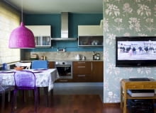 KOLOROWA I WESOŁA. Fantazyjne abażury: z pomalowanej na różowo wikliny oraz z koronki zastąpiły wiszące tu wcześniej lampy o prostych formach. Z kolorystyką wnętrza harmonizuje tapeta w kwiatowy wzór, którą pokryto ścianę przesłaniającą aneks kuchenny.