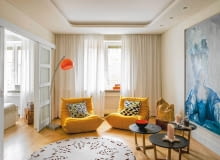 Wydaje się do mieszkania o każdej porze dnia zagląda słońce. Taki efekt daje jasna kolorystyka z akcentami ciepłych żółci i oranżów. Pokój dzienny właściciele urządzali sami. wstawili do niego niewiele mebli, za to o ciekawych, przyciągających uwagę kształtach. aranżacja wnętrza