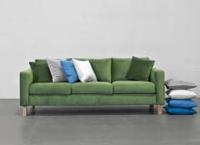 Sofa Kera to połączenie prostej formy i wygody. Występuje w różnych rozmiarach i obiciach, m.in. w aksamitnej tkaninie o głębokim odcieniu zieleni. Sofa Kera to połączenie prostej formy i wygody. Występuje w różnych rozmiarach i obiciach, m.in. w aksamitnej tkaninie o głębokim odcieniu zieleni.