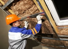 Układanie na metalowym ruszcie drugiej warstwy wełny mineralnej jako ocieplenia dachu