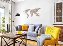 KONTURY KONTYNENTÓW na ścianie nad kanapą zostały wycięte laserem ze sklejki. Wykonawcę tej precyzyjnej roboty gospodarze znaleźli na portalu dawanda.pl; sami pomalowali natomiast sklejkę bejcą - na ten sam kolor co blat stolika kawowego.