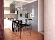 Aranżacja. Projekt 1. Lampa zrobiona ze zwykłego szkła przypomina dawne kryształowe żyrandole. Pasują do niej krzesła z przezroczystego tworzywa sztucznego. WNETRZA KUCHNIA MEBLE OSWIETLENIE ZYRANDOL