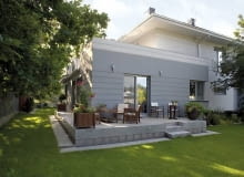 Budynek od ogrodu. Działkę ze wszystkich stron otaczają sosny i dęby elewacja, taras