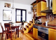 Kuchnia jest pełna ciepłych brązów - taki kolor mają zarówno drewniane elementy wystroju, jak i płytki ceramiczne. Schodki prowadzą na małe poddasze, do królestwa Marysi, córki gospodarzy. UWAGA PONOWNA PUBLIKACJA ZA ZGODA WLASCICIELI WNęTRZA MEBLE KUCHNIE aranżacja