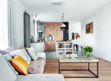 W SZAROŚCIACH I BRĄZACH. Niebanalny stolik z blatem zdobionym motywem mandali gospodyni zamówiła w sklepie guido.pl. Zabudowa kuchenna, zrobiona ze szczotkowanego dębu, mieści lodówkę oraz szafki (wśród nich cargo). Na podłodze w pokoju dziennym leżą dębowe deski, natomiast w kuchni - wzorzyste płytki marki Vives oraz beton firmy Mercadier. Duży grzejnik na ścianie to model Charleston firmy Zehnder.