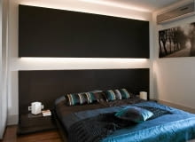 Nad łóżkiem z drewna wenge zainstalowano panel z płyty gipsowo- -kartonowej. Pod nim ukryto oświetlenie. Kolor wenge w aranżacji wnętrz - meble w kolorze wenge