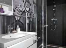 <B>Łazienka cała wyłożona kafelkami jest już raczej nie na czasie. Ale jeśli oprócz ceramiki pojawią się w niej inne materiały, trafi wysoko na?listę?modnych rozwiązań. Oto trzy wnętrza, w których płytki mają dobre towarzystwo.</B> <BR />WNĘTRZE 1 - FOTOTAPETA I FORNIR. Łazienka jest utrzymana w kontrastowej, czarno-białej kolorystyce, nawiązującej do wystroju reszty domu. Stąd m.in. gresowa szachownica (10 x 10 cm) na podłodze - identyczna znajduje się w kuchni i?korytarzu. Z pomieszczenia korzysta osoba niepełnosprawna poruszająca się na wózku, dlatego kabina prysznicowa wydzielona taflami hartowanego szkła jest większa niż standardowa. Nie ma też w?niej brodzika, a?tylko odpływ liniowy zainstalowany w podłodze. Umywalka została osadzona na wiszącej szafce z lakierowanej płyty MDF. Wielką ozdobą wnętrza jest fototapeta przedstawiająca Nowy Jork. łazienka, ściany w łazience, aranżacja łazienki