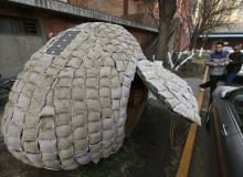 Visitors take photos of an egg-shaped mobile house near its owner Dai Haifei's office building in Beijing December 3, 2010. Dai, who is from central China's Hunan province and cannot afford Beijing's high rental prices, has been living in the house which costs about 6427 yuan ($965). The house is made of bamboo strips, steel bars, heat prevention and waterproof materials, sacks filled with fermented wood chips and grass seeds, as well as one solar-cell panel, local media reported. REUTERS/Petar Kujundzic (CHINA - Tags: BUSINESS SOCIETY)