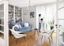 Salon z oknami wychodzącymi na południe to najwidniejszy pokój w mieszkaniu. Biblioteczka została zrobiona na zamówienie. Witrynkę (w rogu za drzwiami) gospodyni zestawiła z prostą welurową kanapą ze sklepu Livingroom, stolikiem vintage (Nap) i fotelikami z lat 60., na których uwielbia wylegiwać się kotka Hesia.