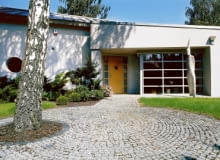 Wejścia do domu strzeże dwumetrowy totem. Drewniane drzwi - poszerzone i podkreślone wnęką ładnie kontrastują z aluminowymi elementami wykończenia budynku. UWAGA ! PONOWNA PUBLIKACJA ZA ZGODA WLASCICIELI !