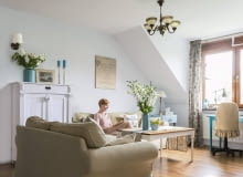 W SALONIE nowymi meblami są tylko kanapy w praktycznych pokrowcach. Reszta to sprzęty z odzysku pomysłowo przerobione przez panią domu (np. walizka w roli stolika). Jej dziełem jest też obraz - kawałek starej tkaniny naciągnięty na blejtram. salon, wystrój wnętrz, aranżacje wnętrz, retro wnętrza