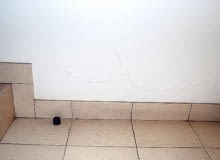 Łuszcząca się farba na ścianie przy podłodze parteru Łuszcząca się farba na ścianie przy podłodze parteru