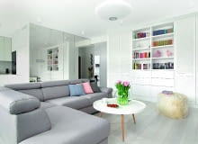 LUSTRZANE FRONTY sprawiły, że wielka szafa (w której oprócz półek ukryto pralkę oraz wysuwany kosz na pranie) nie przytłacza wnętrza, a wręcz przeciwnie - dodatkowo je powiększa. Taflą lustra wyłożono też bok wysokiej zabudowy kuchennej stykającej się z szafą. Lampę nad stolikiem kawowym właścicielka znalazła na aukcji internetowej. Tkaninę naciągnięto na metalowy stelaż; wieczorem, gdy jest włączone światło, abażur przypomina - zdaniem Małgorzaty - talerz z delikatnej porcelany.