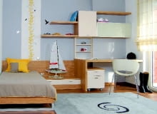 W niewielkim uczniowskim pokoju dobrze sprawdzają się meble o neutralnej kolorystyce - wyrazu nada im osobisty dobytek lokatora