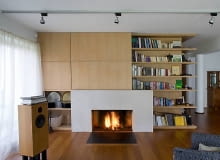 Salon. Szafki nad kominkiem, zamykane gładkimi drzwiczkami bez uchwytów, to domowy minimagazyn różności. Jedną z szafek przeznaczono na barek. ONE TIME USE ONLY DO JEDNOKROTNEJ PUBLIKACJI WNęTRZA, aranżacje, salon, kominek, biblioteka