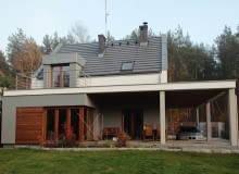 Widok od strony ogrodu. Zadaszenie nad samochodem jednocześnie ochrania przed słońcem i deszczem taras prowadzący do salonu realizacje domów, domy zdjęcia, dom jednorodzinny