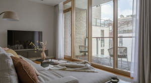 Salon otwierający się na loggię poprzez panoramiczne przeszklenie  to wymarzone miejsce  do przesiadywania i podpatrywania miejskich widoków.