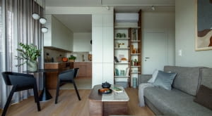 Nieduża strefa dzienna z salonem i aneksem kuchennym dzięki wysokim oknom oraz oszczędnemu wyposażeniu zyskuje poczucie przestrzeni. Wnętrze prezentuje się swobodnie i nie jest przytłoczone nadmiarem mebli czy dodatków.