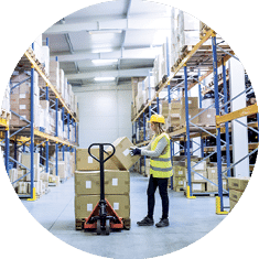 Young female warehouse worker loading up a pallet truck with boxes 