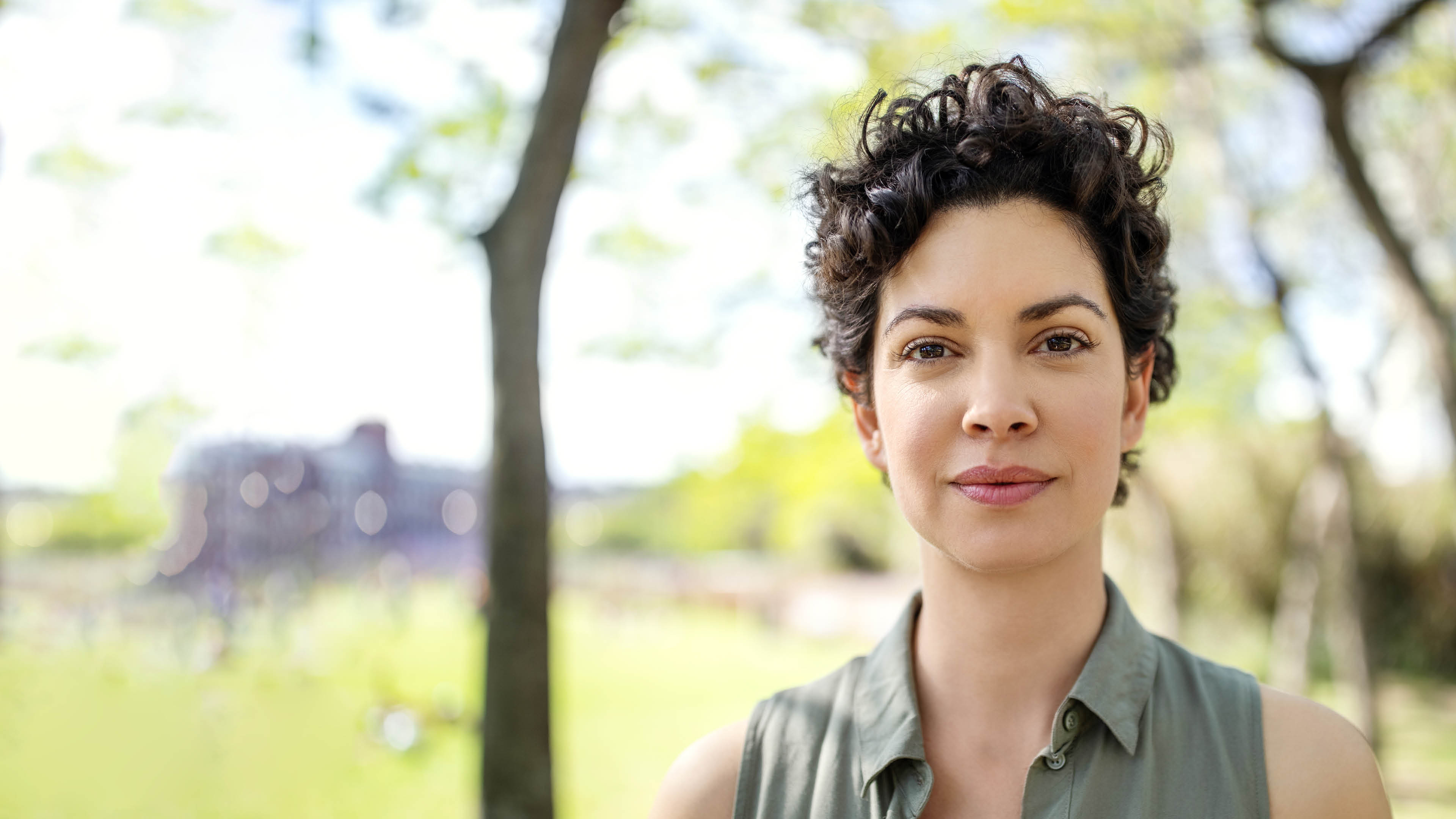 Portrait of a confident young woman standing at the park  Beautiful female in casuals looking at camera 