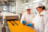 Zwei Auszubildende kontrollieren schokoladenüberzogene Kekse. (Bilder: ZDS) 