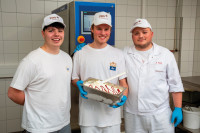 Azubis bei der Eisproduktion: Drei Schüler präsentieren stolz ihre frisch hergestellte Eiscreme.