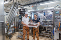 Julia Zotter mit Produktionsleiter Gerald Prasch. Rechts im Hintergrund die Kartonaufrichtmaschine, links die Ishida-Mehrkopfwaage. (Bilder: Ishida)