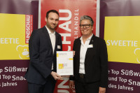 Petra Kissel (li.) von der Edeka übergibt die Urkunde an Eliza Jahn von Katjes Fassin