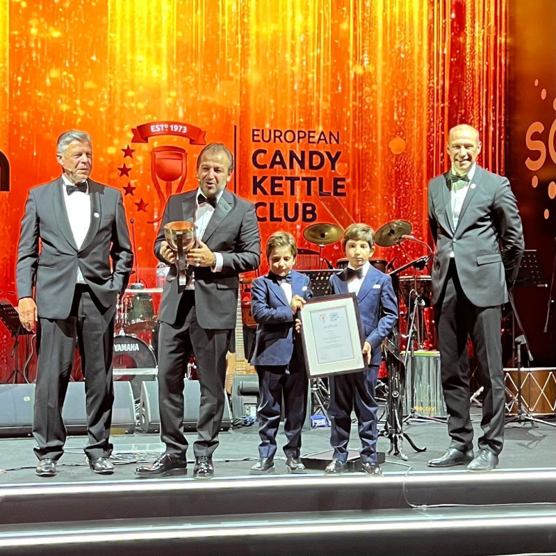 Heiko Kühn (li.) und Thomas Bischof (re.), die beiden Vorsitzenden des European Candy Kettle Clubs, übergaben die Trophäe an Erdoğan Çoban, den CEO von Şölen. Dessen Söhne zeigten stolz die Urkunde. (Foto: ECKC)