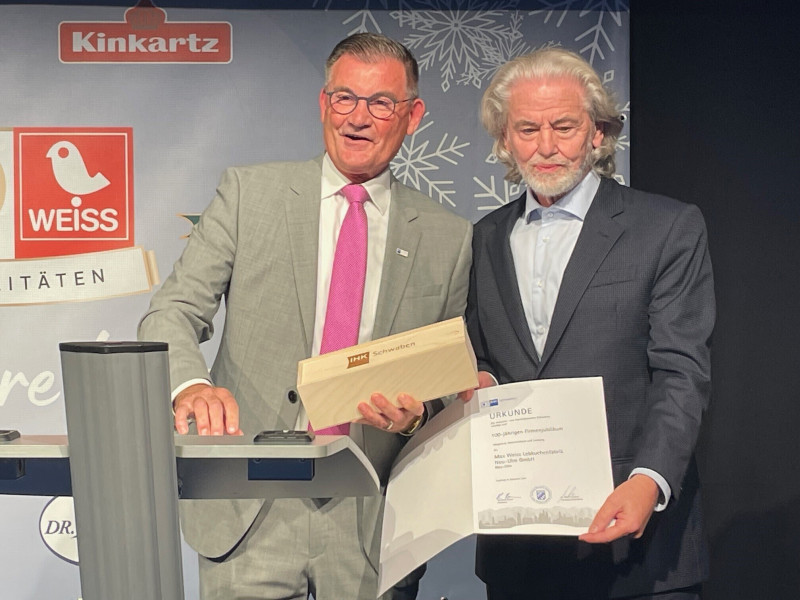 Gerd Stiefel, ­Vizepräsident der Industrie- und Handels­kammer 
Schwaben, ­überreichte ­Lambertz-Inhaber Dr. Hermann ­Bühlbecker ein Präsent und die Urkunde zu 100 Jahre Max Weiss Lebkuchenfabrik Neu-Ulm GmbH.
(Foto: Lambertz) 